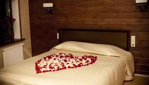 Лепестки роз на кровати. Романтическая атмосфера