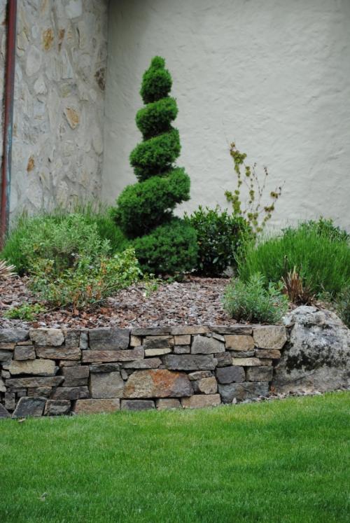 Клумба из камней вдоль забора. Виды дизайнерских решений