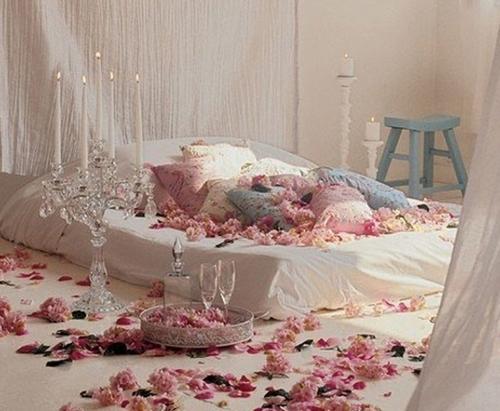 Крупным Планом лепестки роз на кровати. Украшение комнаты для романтического вечера цветами