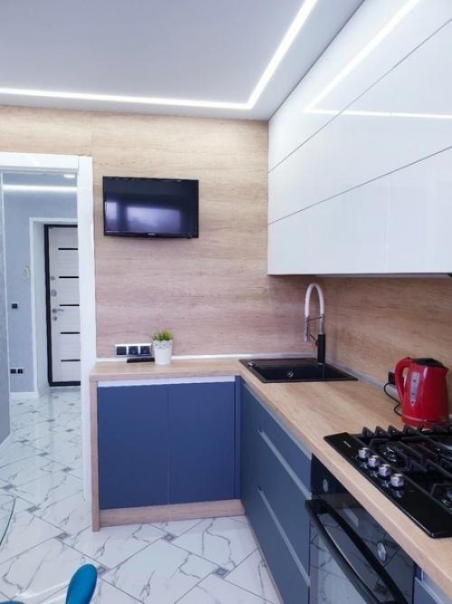 Синий цвет в интерьере кухни гармонирует со светло-серыми и белыми оттенками оттенками. 01