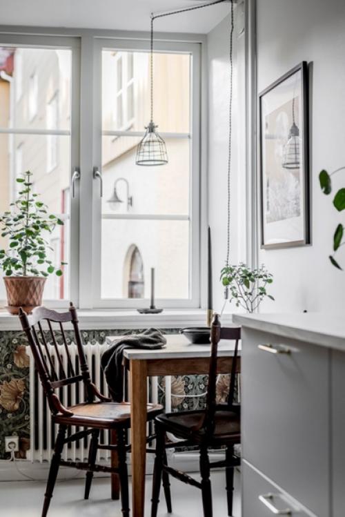 Скандинавская квартира, оформленная в мягких оттенках, но с активными обоями и зелёными стульями. 07