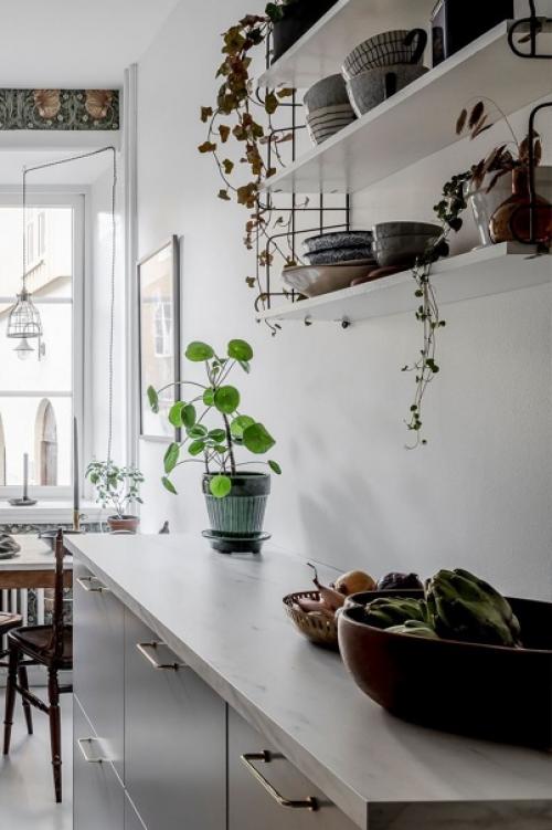 Скандинавская квартира, оформленная в мягких оттенках, но с активными обоями и зелёными стульями. 02