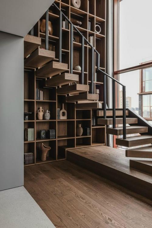 Квартира построена вокруг атмосферы и звука: пятиметровый стеллаж, большие окна и выразительная мебель формируют характер пространства. 01