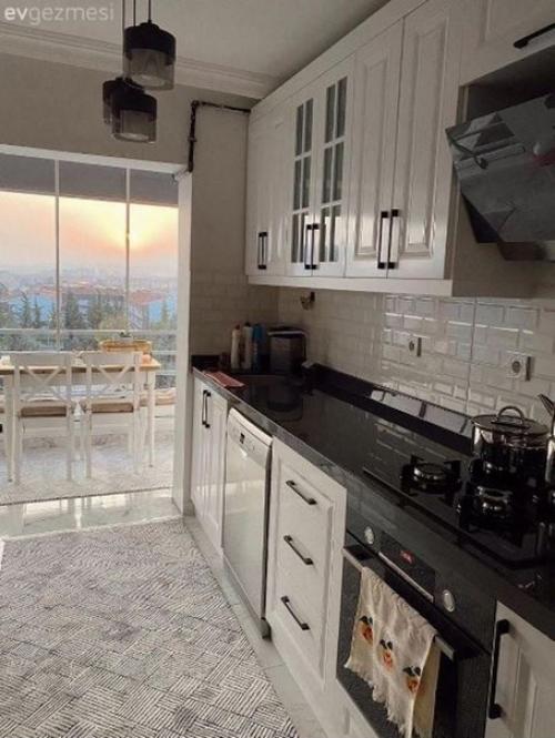 Кухня с чудесной столовой зоной на присоединенном балконе в квартире молодой семейной пары. 02