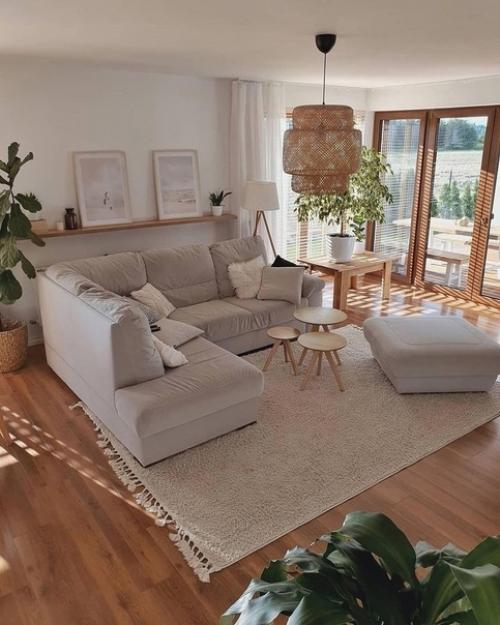 Просторная гостиная и белая кухня в доме, который привлекает ощущением свободы, распределением света и удобным зонированием. 01