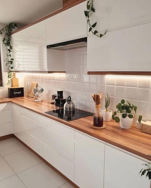 Просторная гостиная и белая кухня в доме, который привлекает ощущением свободы, распределением света и удобным зонированием. 08