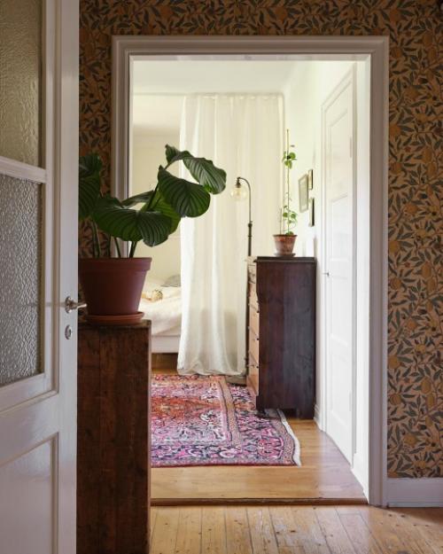 Уютная и просторная квартира - студия с белой кухней и комнатой с большим окном. 02