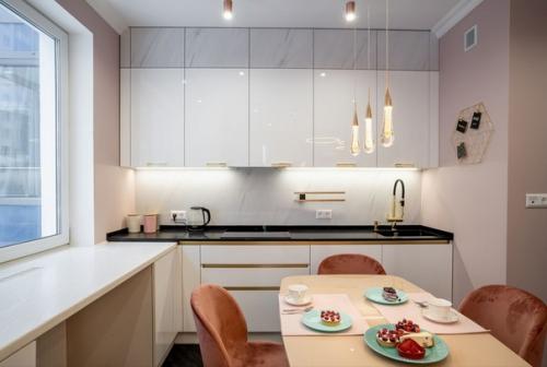 Современный бело-розовый интерьер кухни, объединенной с гостиной. 01