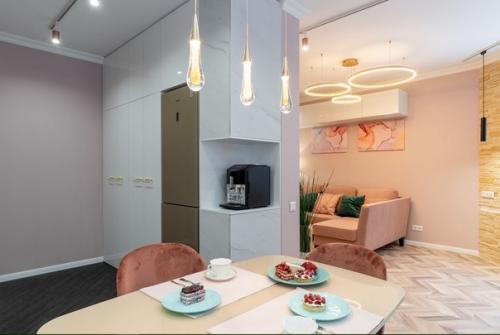 Современный бело-розовый интерьер кухни, объединенной с гостиной. 03