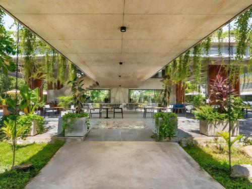Архитекторы студии Khoan + Partners вдохнули жизнь в недостроенное бетонное здание в Камбодже, превратив его в стильное кафе с биофильным дизайном. 01
