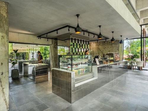 Архитекторы студии Khoan + Partners вдохнули жизнь в недостроенное бетонное здание в Камбодже, превратив его в стильное кафе с биофильным дизайном. 03