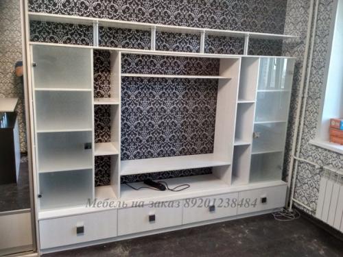 Белая мебель, в том числе и стенка, в интерьере гостиной способна подчеркнуть изысканный вкус хозяев квартиры и их гостеприимность. 01