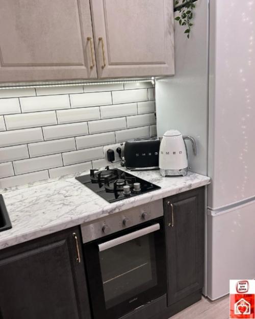 Кухня обставлена в светлых оттенках, создавая уютную атмосферу. 02