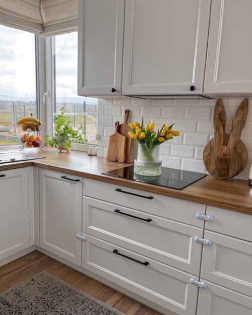 Белая кухня, живые цветы и мебель из дерева. 01