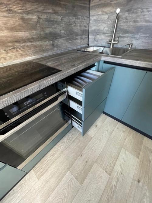 Кухонный гарнитур темно-зеленого цвета отлично впишется в интерьер любой кухни. 02