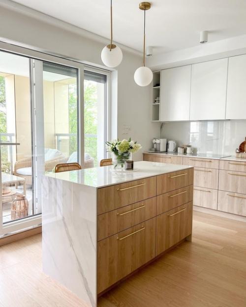 Белый, бежевый отлично подружились в этой кухне - гостиной с фактурой светлого дерева. 01