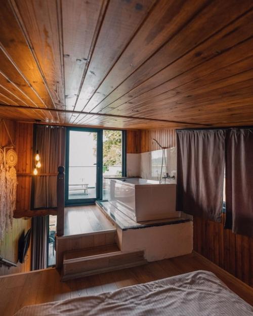 Небольшой модульный дом из контейнеров с простым тёплым интерьером из деревянных панелей, а находится он на берегу озера сапанджа в Турции. 05