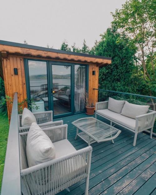 Небольшой модульный дом из контейнеров с простым тёплым интерьером из деревянных панелей, а находится он на берегу озера сапанджа в Турции. 02