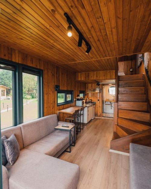 Небольшой модульный дом из контейнеров с простым тёплым интерьером из деревянных панелей, а находится он на берегу озера сапанджа в Турции. 01