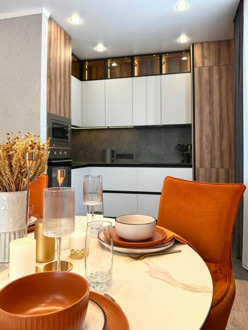 Как спрятать кухню в общем пространстве, чтобы она не перетягивала внимание на себя? 

