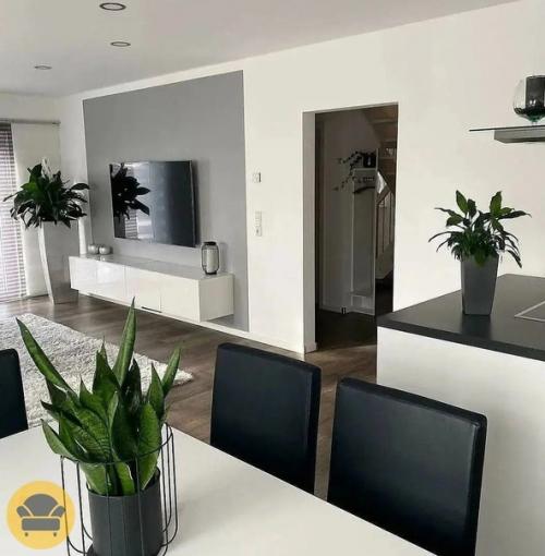 Стильный и современный интерьер гостиной в белом цвете и уклоном на минимализм, а саму обстановку разбавляют растения. 02