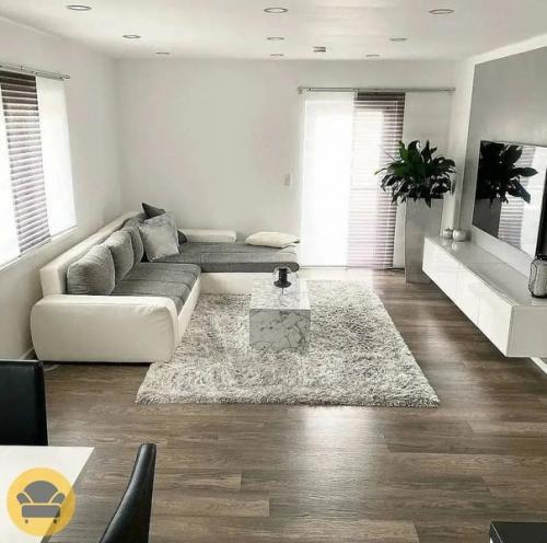 Стильный и современный интерьер гостиной в белом цвете и уклоном на минимализм, а саму обстановку разбавляют растения. 03