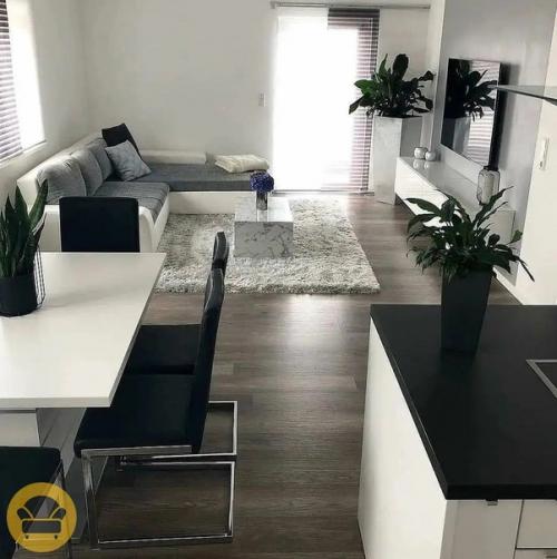 Стильный и современный интерьер гостиной в белом цвете и уклоном на минимализм, а саму обстановку разбавляют растения. 01