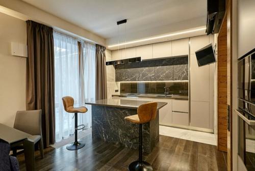 Современный монохромный интерьер общего пространства кухни - столовой и гостиной в ЖК парадный квартал. 01