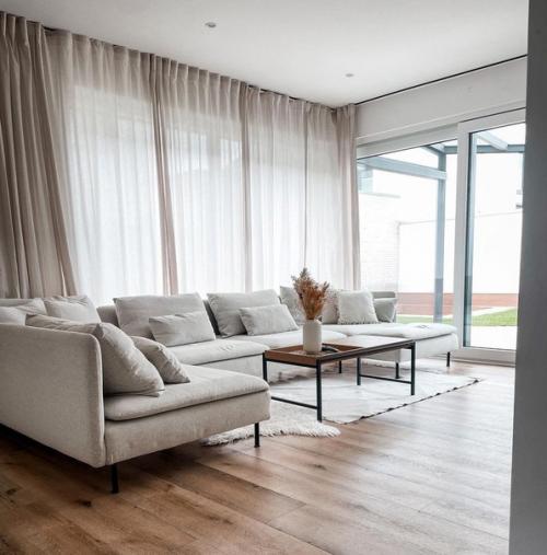 Розовые детали в интерьере дома с шикарным большим диваном в Германии. 01