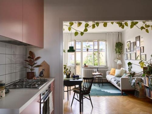 Эта квартира в Стокгольме поражает своей смелой цветовой гаммой на кухне, ведь розовые шкафы не часто встречаются в современных интерьерах. 01