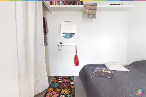 Небольшая квартира на обводном канале с самодельной мебелью, зеркальной колонной и кроватью на подиуме. 08