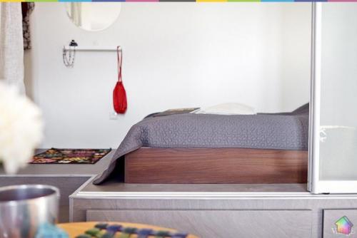 Небольшая квартира на обводном канале с самодельной мебелью, зеркальной колонной и кроватью на подиуме. 06