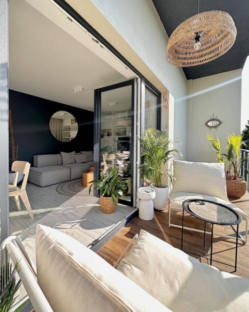Уютная современная квартира с открытым балконом, зелеными растениями и плетеным декором. 03