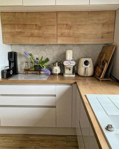 Кухня с белыми и деревянными фасадами, деревянными барными стульями на металлических ножках и круглым столом выглядит очень стильно. 02