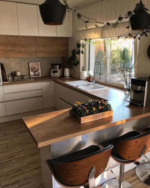 Кухня с белыми и деревянными фасадами, деревянными барными стульями на металлических ножках и круглым столом выглядит очень стильно. 05