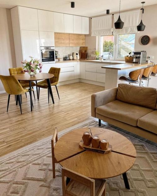 Кухня с белыми и деревянными фасадами, деревянными барными стульями на металлических ножках и круглым столом выглядит очень стильно. 04