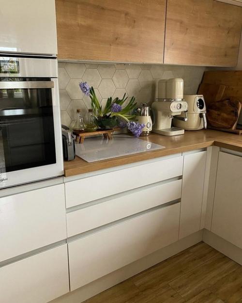 Кухня с белыми и деревянными фасадами, деревянными барными стульями на металлических ножках и круглым столом выглядит очень стильно. 03