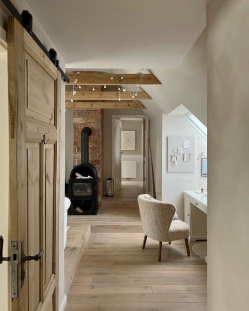 Уютная атмосфера современной мансардной квартиры с деревянными балками и небольшой печью - камином. 04