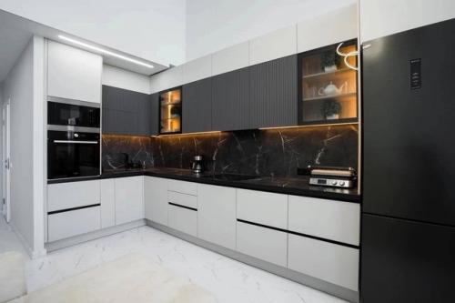 Для кухни - гостиной угловая кухня в ахроматических цветах - современное и функциональное решение. 01