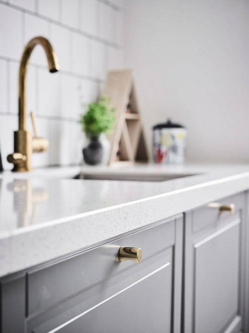 Эта компактная шведская квартира включает светлую кухню, с бледными деревянными полами и красивыми серыми кухонными шкафами. 01