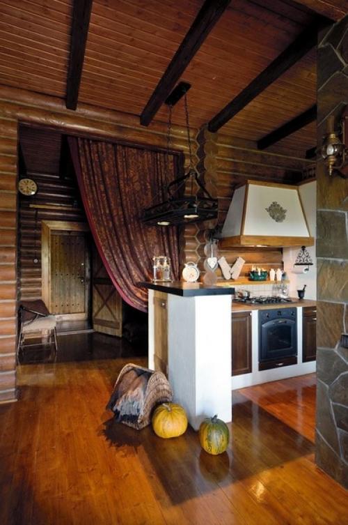 Уютный и очень атмосферный интерьер кухни - гостиной в загородном бревенчатом доме. 01