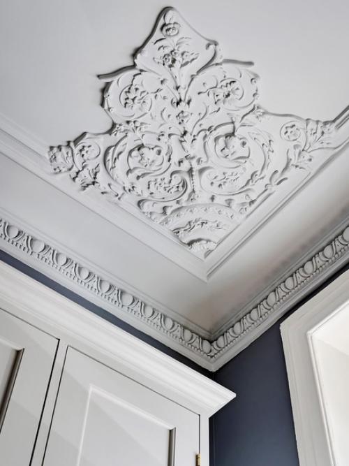 Лепной декор на потолке и необычные рамы окон в интерьере квартиры с серо-голубыми стенами и светильниками в скандинавском стиле. 01