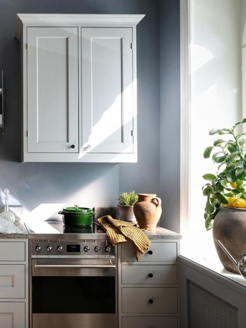 Лепной декор на потолке и необычные рамы окон в интерьере квартиры с серо-голубыми стенами и светильниками в скандинавском стиле. 06