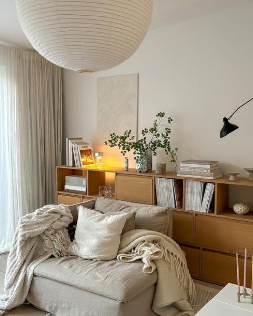 Светлый и стильный интерьер современной квартиры с деревянными элементами, теплым освещением и красивым текстилем и декором. 01